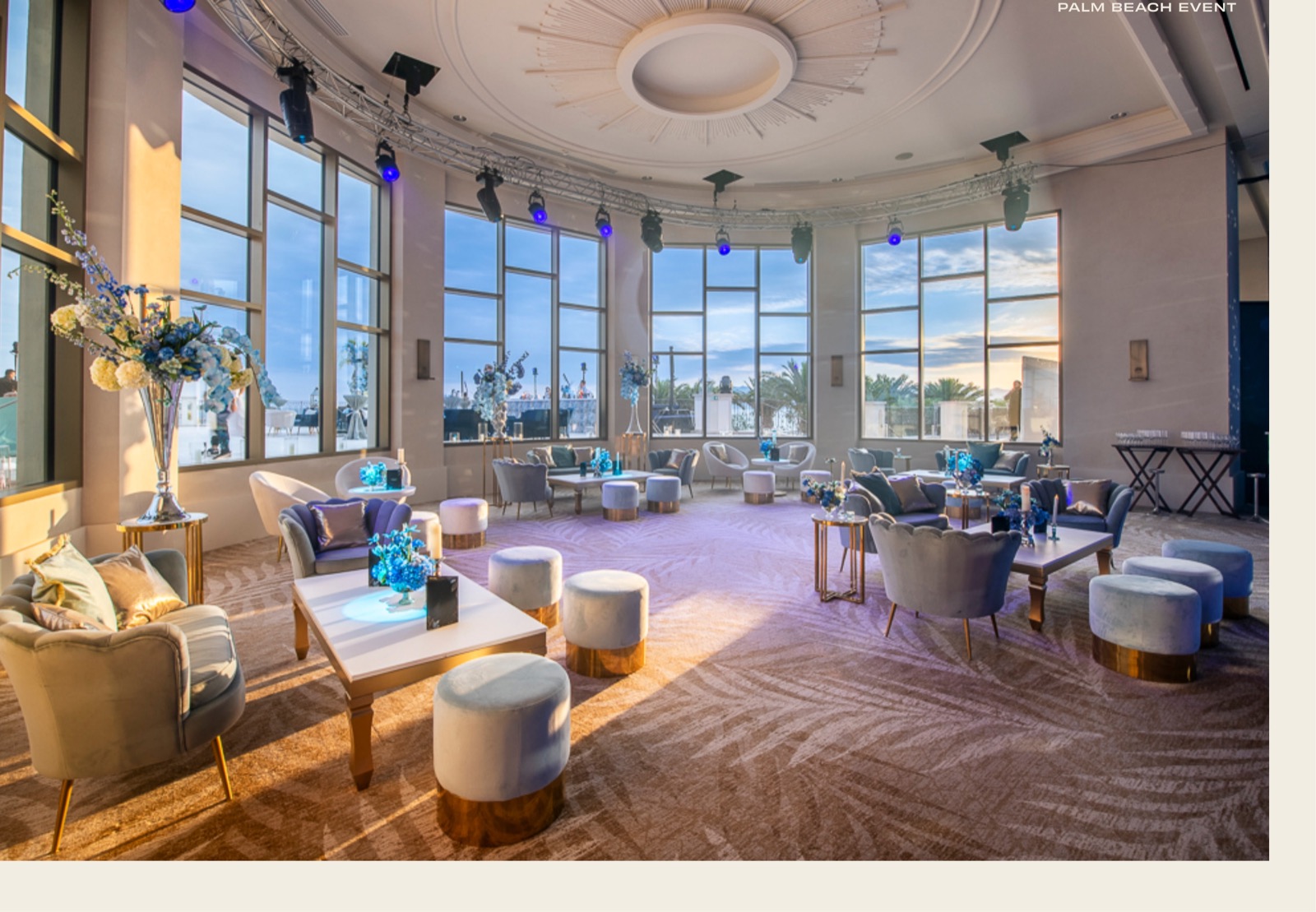 La rotonde du Palm Beach aménagée en salon, fauteuils et guéridons face aux baies vitrées au coucher du soleil