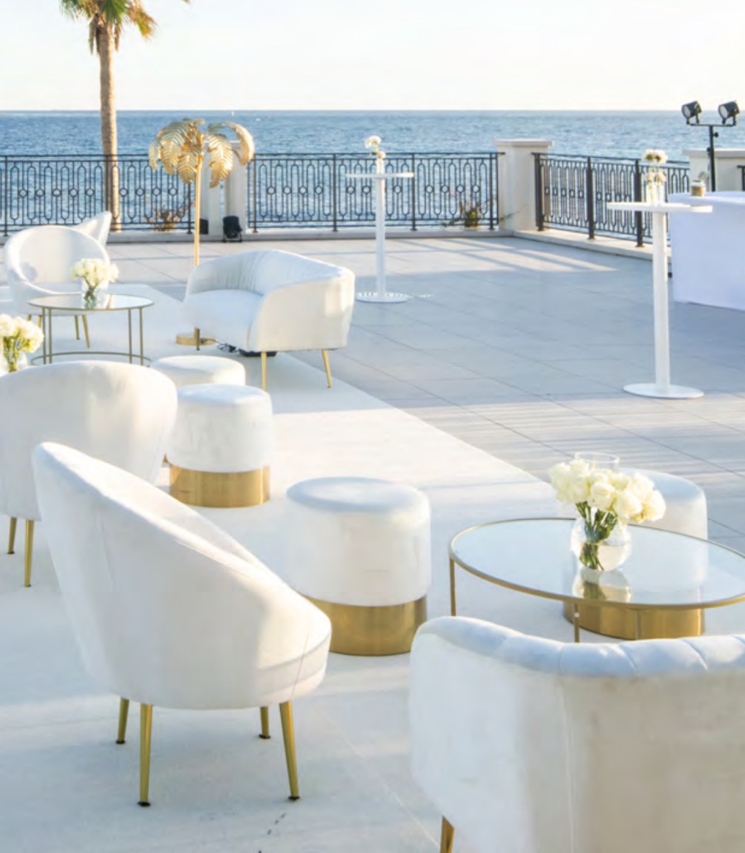 La terrasse du Palm Beach face à la mer, fauteuils blancs et balustrade de fer forgé en fin de journée